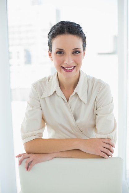 Content élégante femme brune posant en regardant la caméra