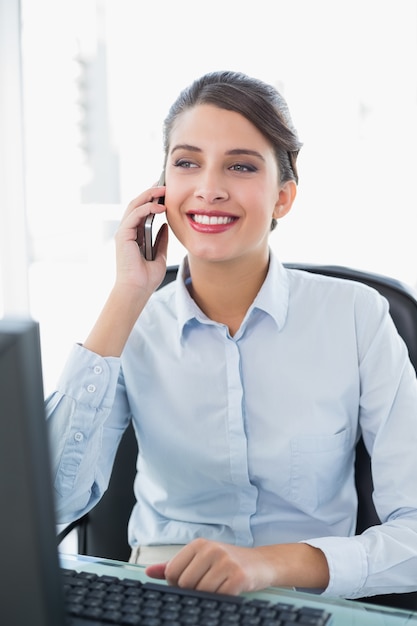 Contenu classy brun aux cheveux femme d&#39;affaires faisant un appel téléphonique