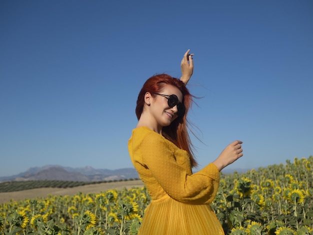 Contenu femme dansant dans le champ de tournesol