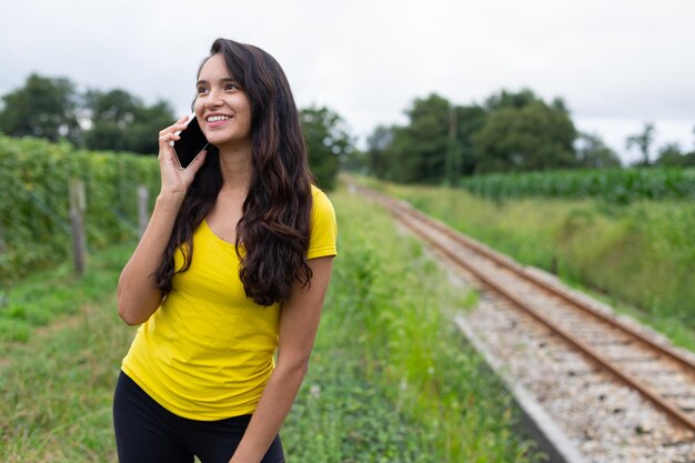 Contenu jeune ethnique ayant un appel téléphonique dans la nature