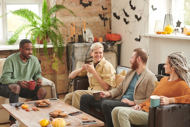 Photo contenu de jeunes amis multiethniques buvant du café et partageant des nouvelles tout en se rassemblant sur hallo