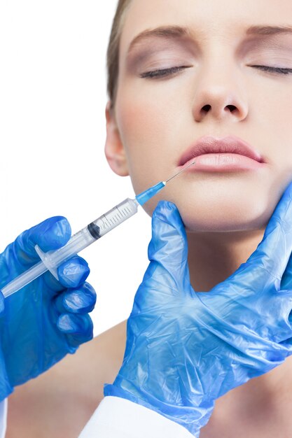 Contenu joli modèle ayant une injection de botox sur les lèvres