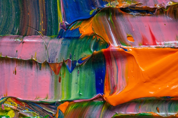 Contexte artistique Différentes couleurs vives des peintures à l'huile sont mélangées dans une palette en gros plan.