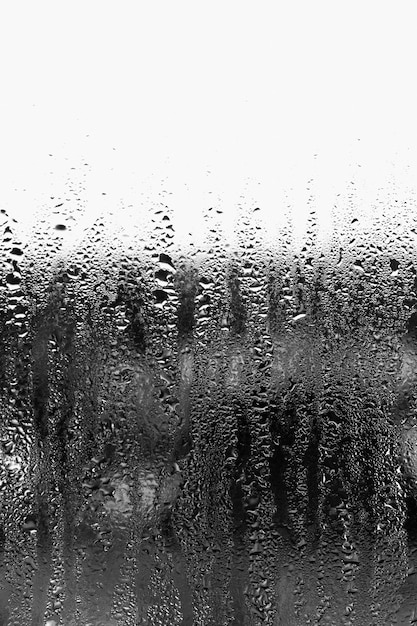 Contexte de condensation de gouttelettes d'eau sur le verre, humidité et brouillard derrière le verre, mauvais temps, pluie