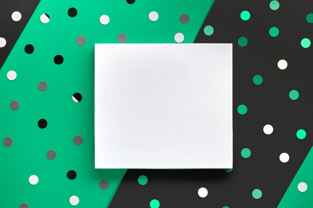 Contexte festif avec copie-espace sur toile. Design plat sur fond de papier vert et noir en couches séparées avec des confettis, des pois, des cercles.