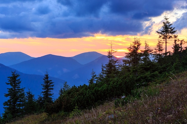 Contour de montagne sur fond de ciel du soir (avec nuages). Vue du crépuscule du coucher du soleil d'été (Carpates, Ukraine).