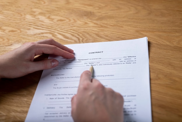 Contrat de vente de papier sur le bureau en mains avec pen pov