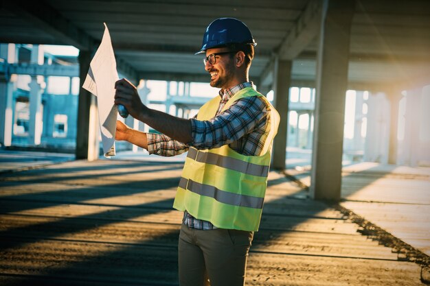 Contremaître De Construction Sur Le Chantier Avec Plan