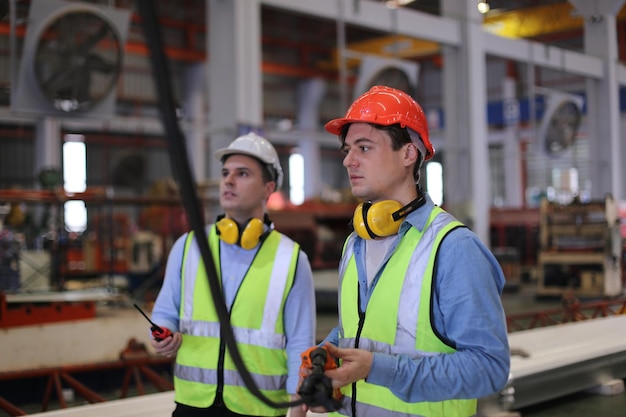 Contremaître ou ouvrier travaillant sur le site de l'usine vérifier la machine ou les produits sur le site Ingénieur ou technicien vérifiant le matériel ou la machine sur l'usine industrielle et l'usine