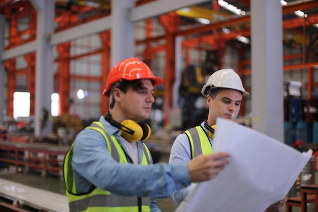 Contremaître ou ouvrier travaillant sur le site de l'usine vérifier la machine ou les produits sur le site Ingénieur ou technicien vérifiant le matériel ou la machine sur l'usine industrielle et l'usine