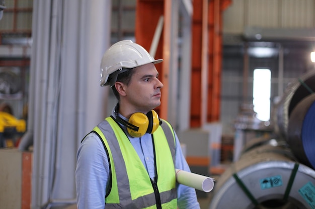 Contremaître ou ouvrier travaillant sur le site de l'usine vérifier la machine ou les produits sur le site Ingénieur ou technicien vérifiant le matériel ou la machine sur l'usine industrielle et l'usine