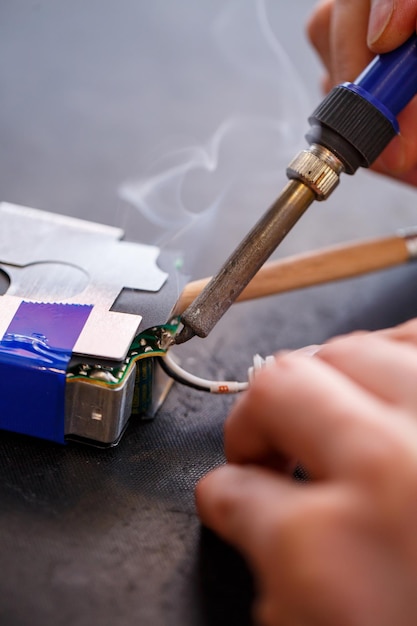 Un contremaître répare un appareil électrique dans son bureau de réparation.