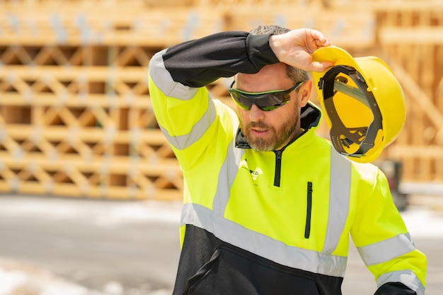 Contremaître surmené fatigué dans un casque à nouvelle maison en construction constructeur sur chantier ma