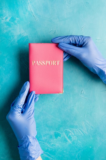 Contrôle des passeports Restriction de voyage Mains dans des gants de protection tenant une carte d'identité étrangère sur un espace de copie bleu Prévention de la pandémie Mesures d'hygiène Nouvelle normalité