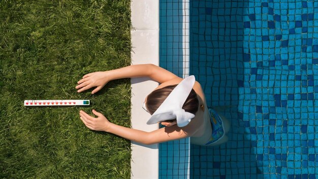 Photo contrôle de la qualité de l'eau d'une piscine à l'aide d'une bande d'essai avec chlorine et algues.