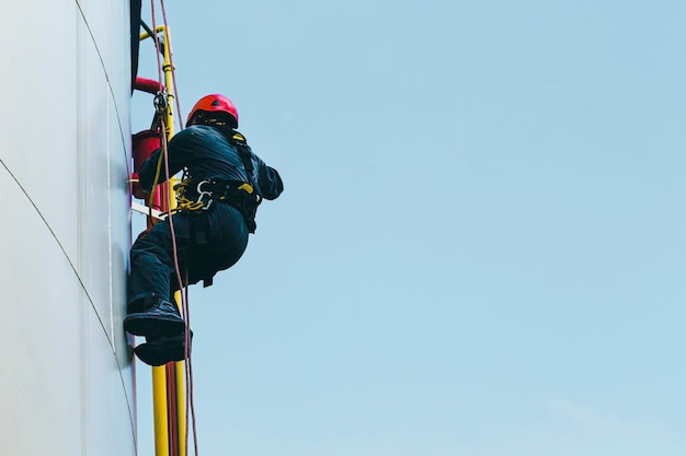 Contrôle de sécurité de la hauteur d'accès à la corde du travailleur masculin de l'épaisseur du réservoir d'huile et de gaz de stockage