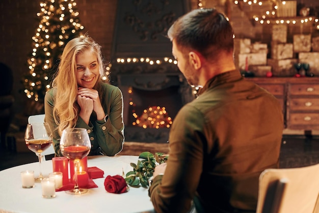 Conversation active Un jeune couple charmant dîne ensemble à l'intérieur