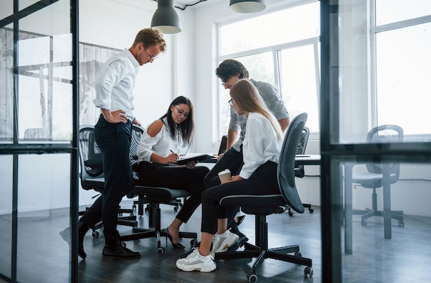 Conversation active. Jeunes gens d'affaires en vêtements formels travaillant au bureau.