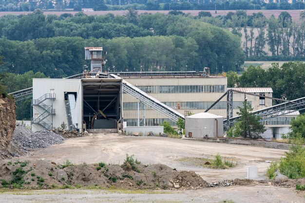 Convoyeurs à bande de grands silos et équipement minier dans une carrière