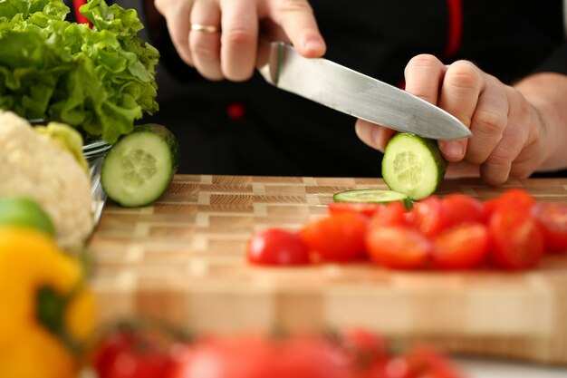 Cook tient un couteau à la main et coupe