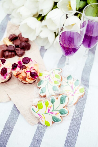 Un cookie feuille violet et vert se trouve à côté d'un verre de vin.