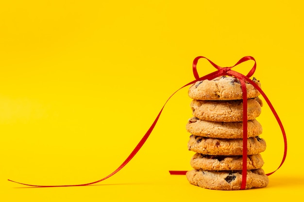 Cookies attachés avec un ruban rouge sur fond jaune