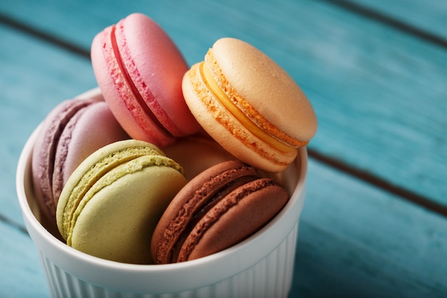 Les cookies aux macaronis sont placés dans une assiette blanche sur un fond en bois bleu.