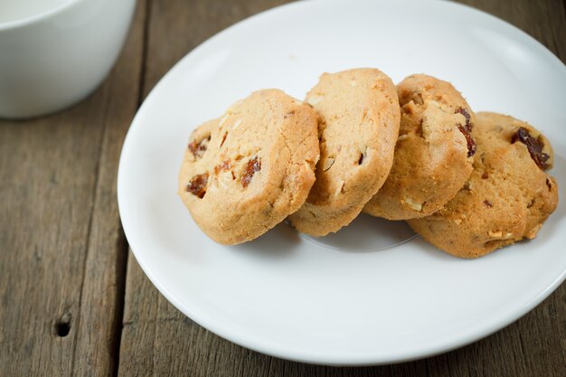 Cookies aux pépites de chocolat sur un disque blanc sur une table en bois