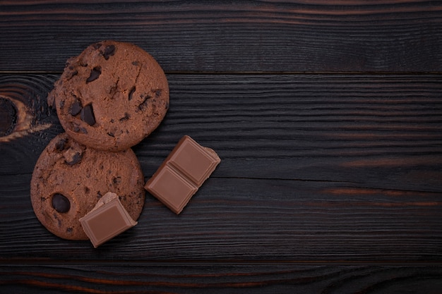 Cookies aux pépites de chocolat sur une vieille table en bois sombre