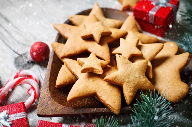 Cookies, cadeaux et branches de sapin sur une table en bois.