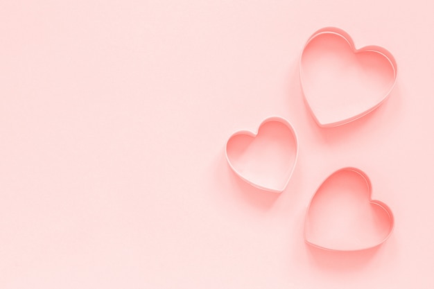 Cookies coupeurs roses en forme de coeur sur fond rose pastel, colar tonique. Modèle d&#39;amour romantique