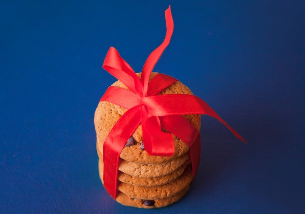 Cookies à égalité avec un ruban rouge pour un cadeau sur le fond bleu