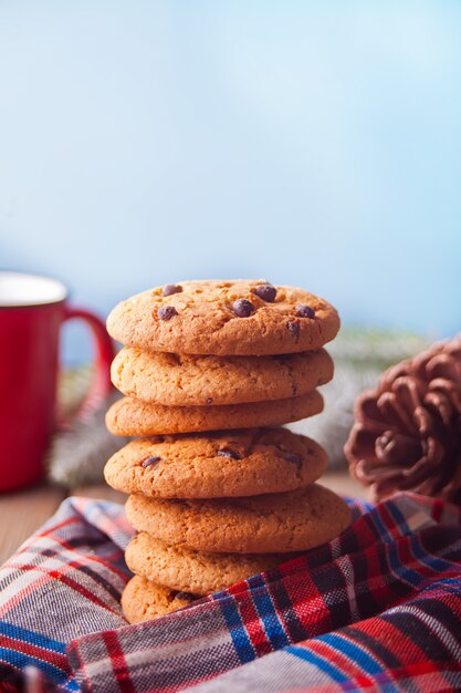 Cookies avec une tasse de chocolat chaud, cône sur une table en bois