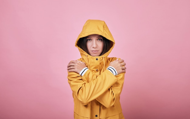 Cool charmant imperméable femme triste avec capuche habillée est gelé et tremblant