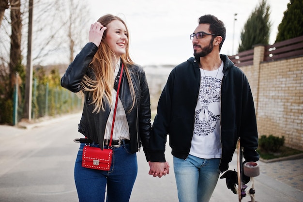 Cool couple multiracial marchant avec longboard