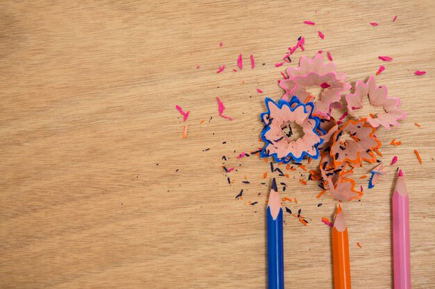 Copeaux de couleur avec des crayons de couleur sur table en bois