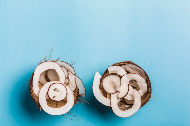 Copeaux de noix de coco dans un bol de noix de coco sur un bleu