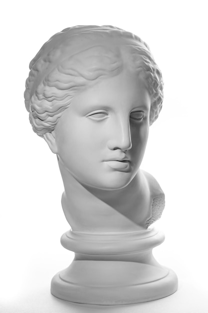 Copie en gypse blanc de l'ancienne statue de la tête de Vénus de Milo pour les artistes sur fond blanc. Sculpture en plâtre d'un visage de femme.