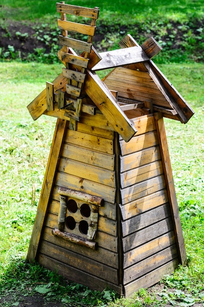 Copie réduite d'un moulin à vent se dresse sur l'herbe verte dans le parc