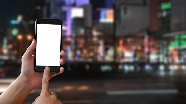 Copier les gros plan espace mains maquette smartphone sur la ville de nuit du Japon flou fond.