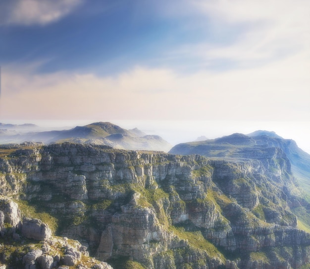 Copiez l'espace avec un paysage pittoresque de nuages dans le ciel couvrant le sommet de Table Mountain au Cap par un matin brumeux Une vue imprenable du haut d'une vallée rocheuse après un sommet sur une montagne