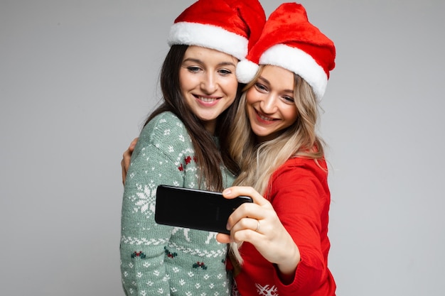 Copines en bonnets de Noel faisant selfie.