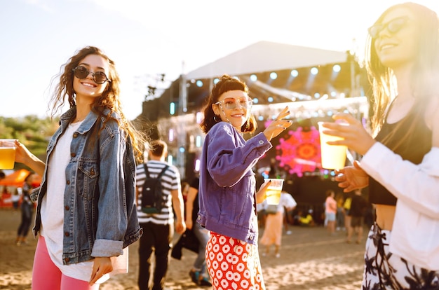 Photo copines buvant de la bière et s'amusant au festival de musique amitié et célébration fête sur la plage