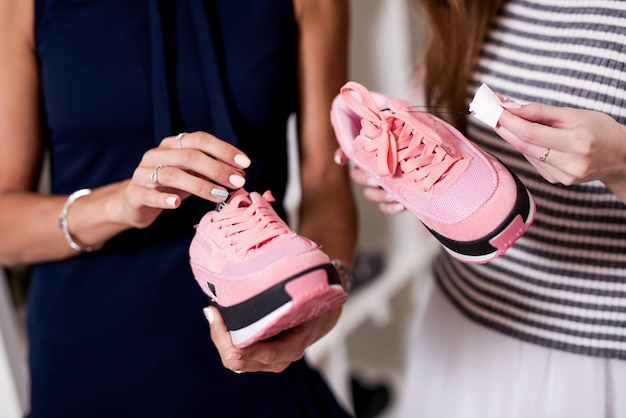 copines examinant une nouvelle paire de chaussures de sport