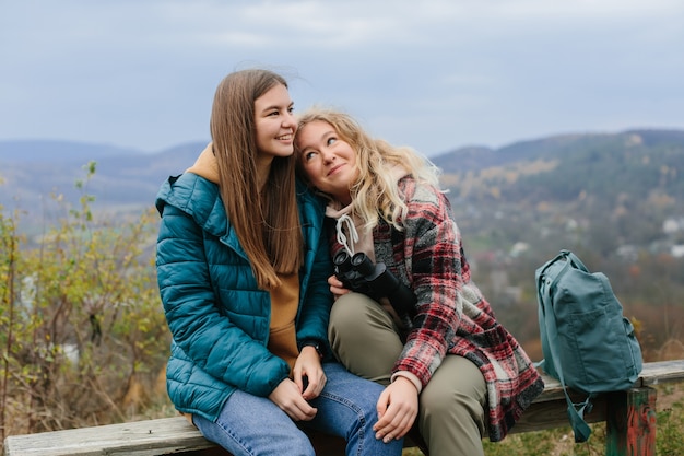 Les copines se reposent sur un banc dans les montagnes