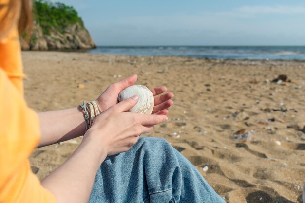 Coquillage entre les mains d'une fille sur la plage