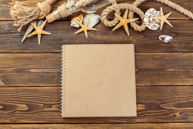 Coquillages et bloc-notes sur une table en bois en vue de dessus avec espace de copie