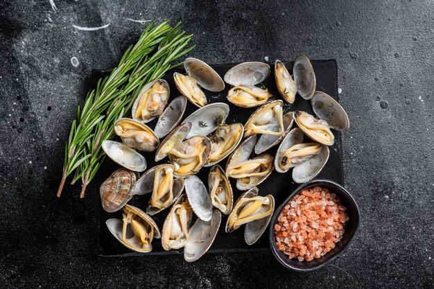 Coquillages cuits à la vapeur Palourdes à l'ail et aux herbes Fond noir Vue de dessus