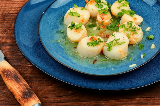 Des coquillages rôtis avec du vert sur une assiette Menu du restaurant