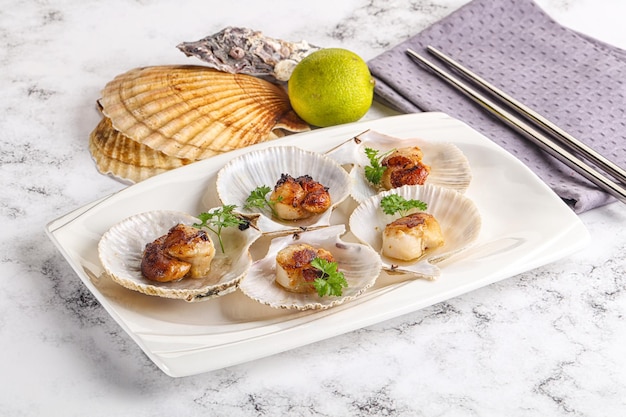 Coquilles de coquilles grillées avec du beurre et du persil